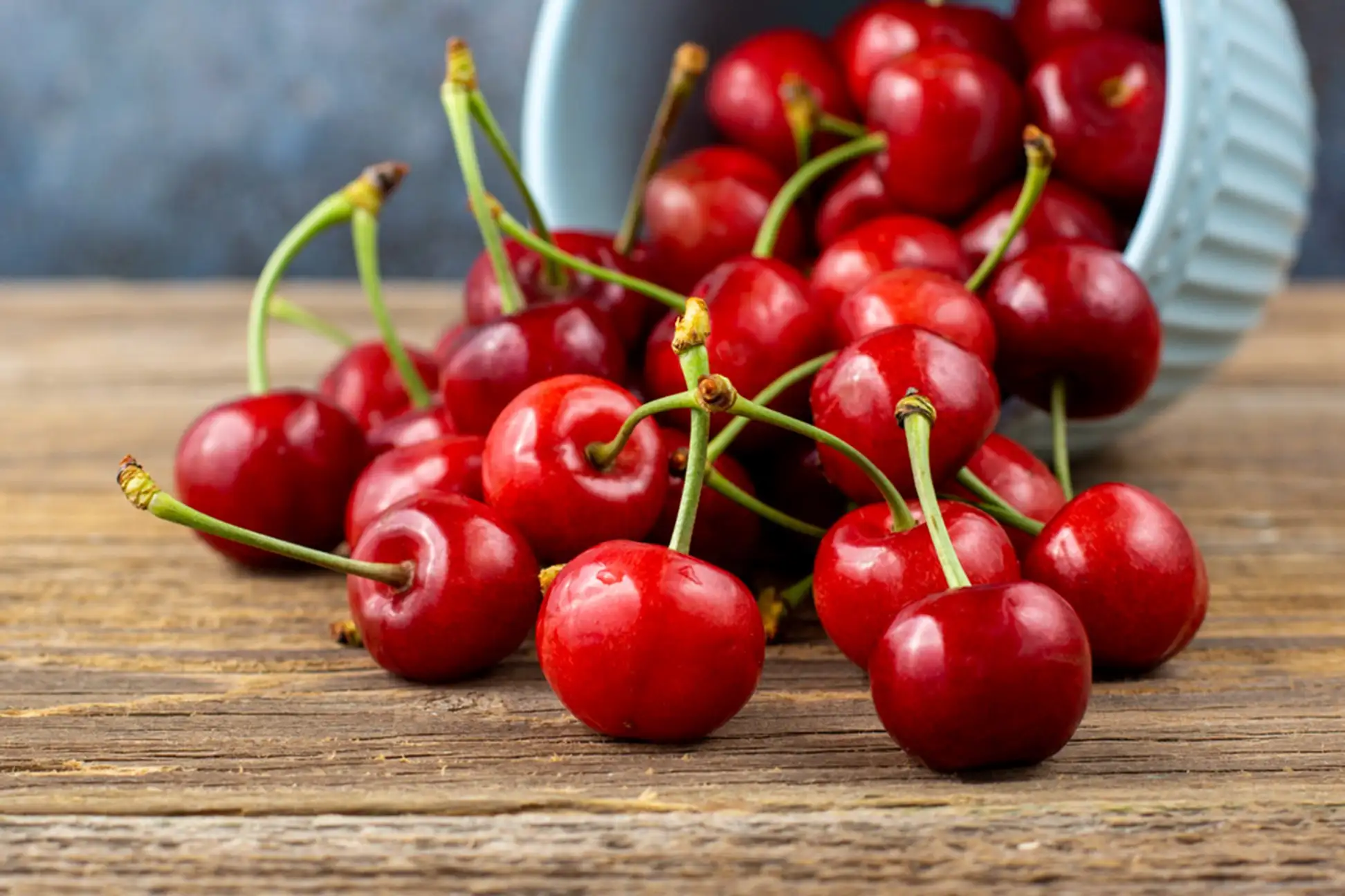 Bunch of cherries sitting on top of a wooden table