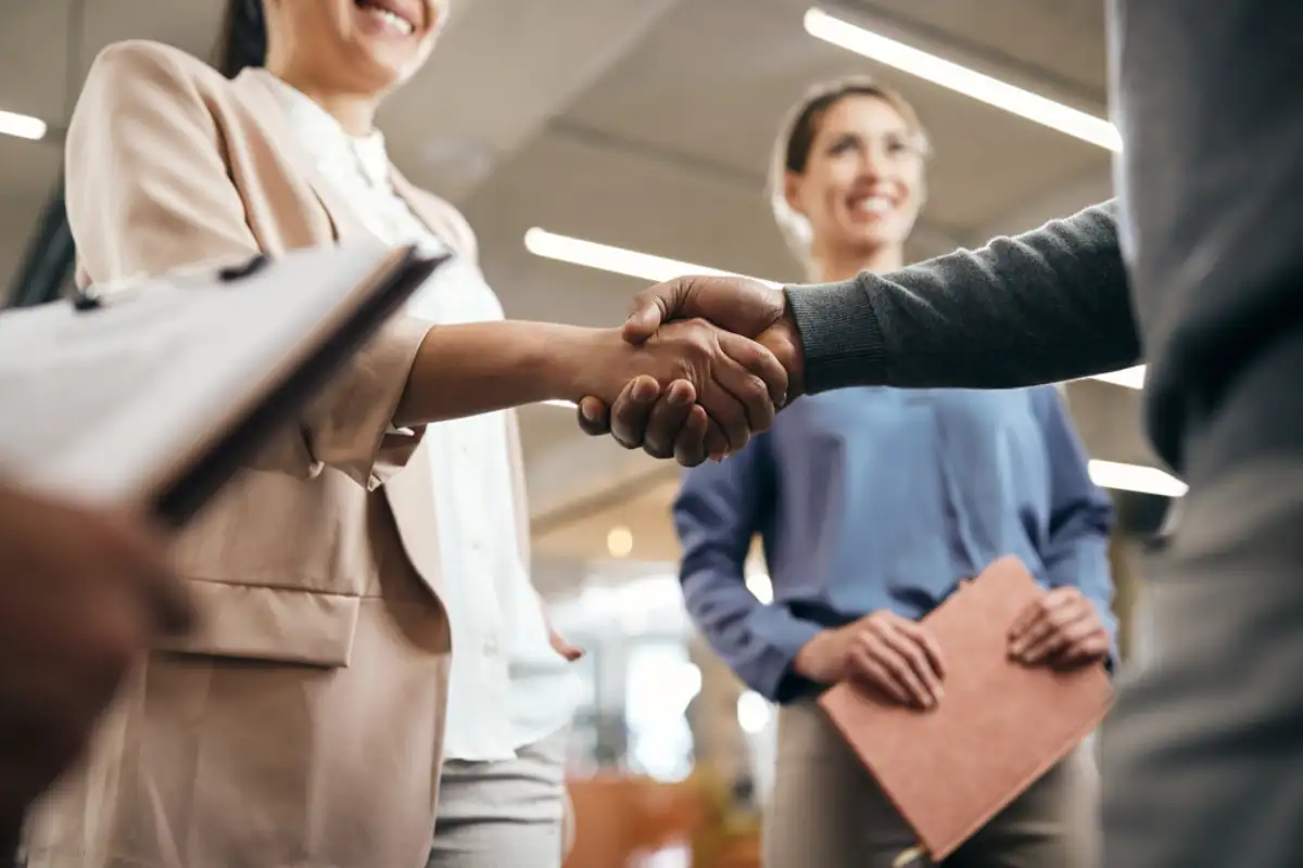 Close-up of corporate managers handshaking after successful agreement in the office
