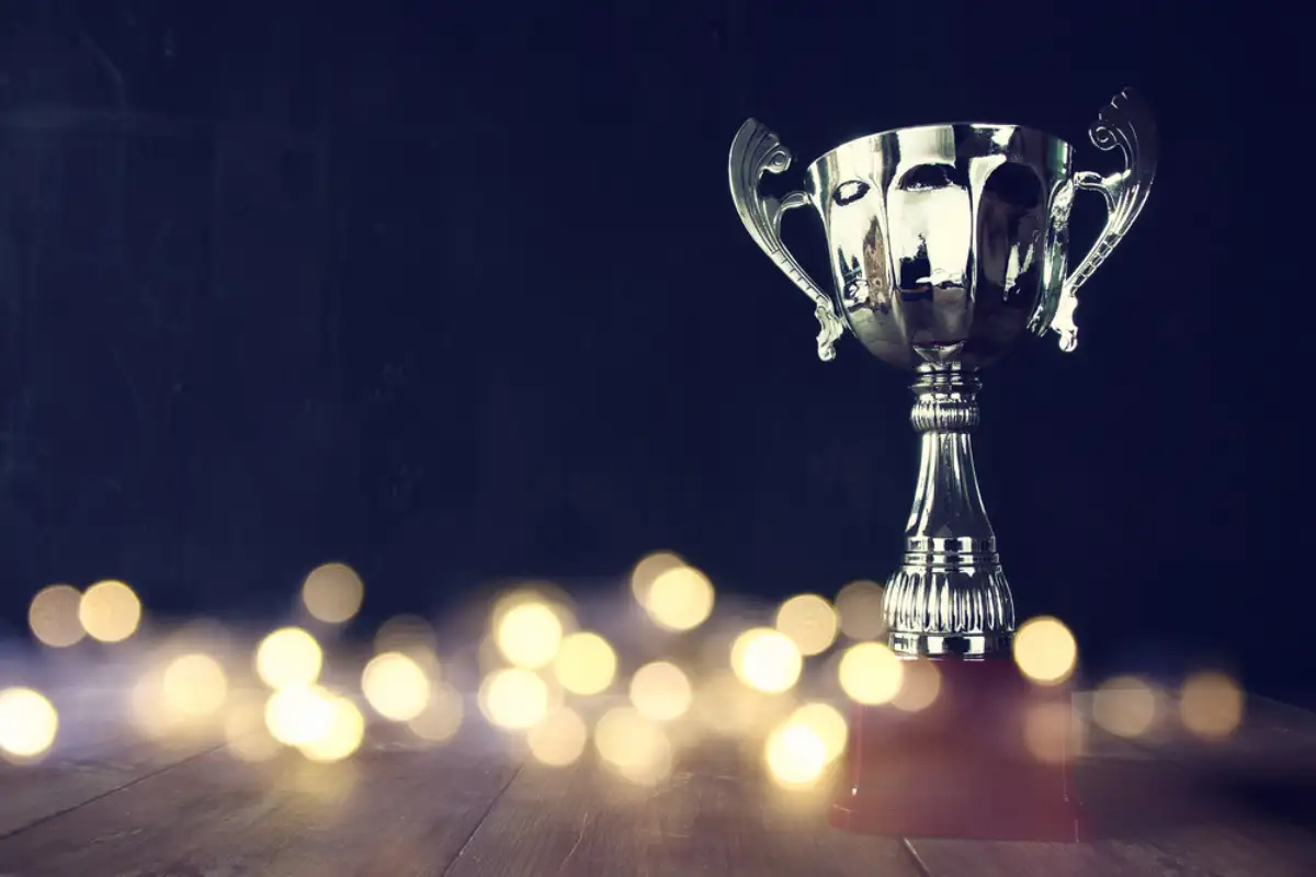 Image of trophy over wooden table and dark background