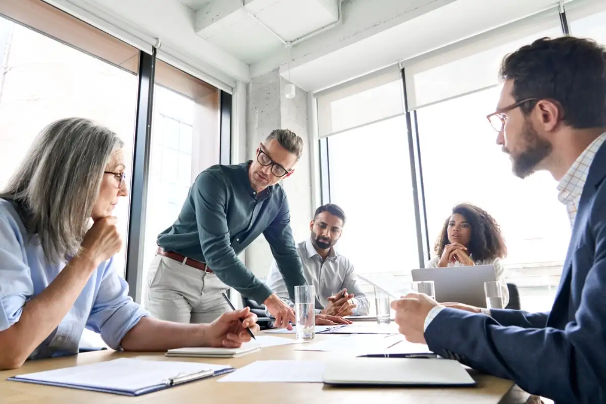 Male mature caucasian ceo businessman leader with diverse coworkers team