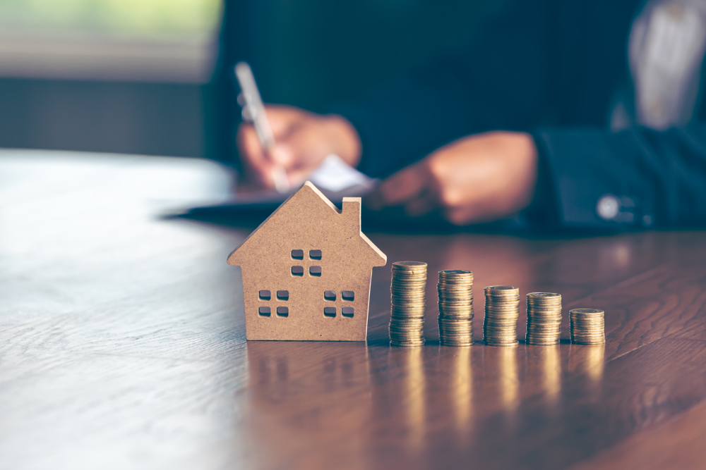 Modeling wooden houses and coins and dollars placed on wooden tables
